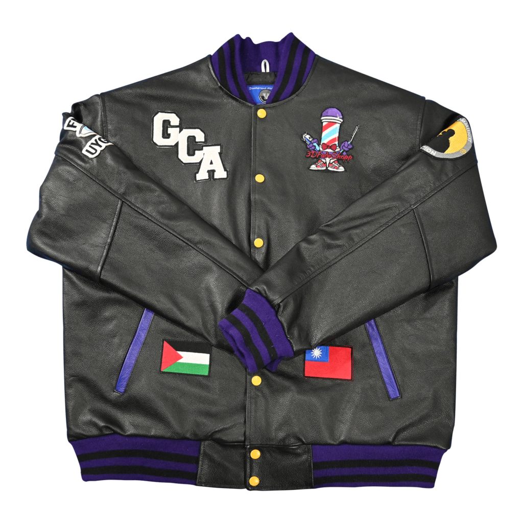 Black leather custom letterman jacket featuring GCA chest lettering, barber pole graphic patch, national flag patches, and purple striped ribbed trim from our letterman jackets online collection.